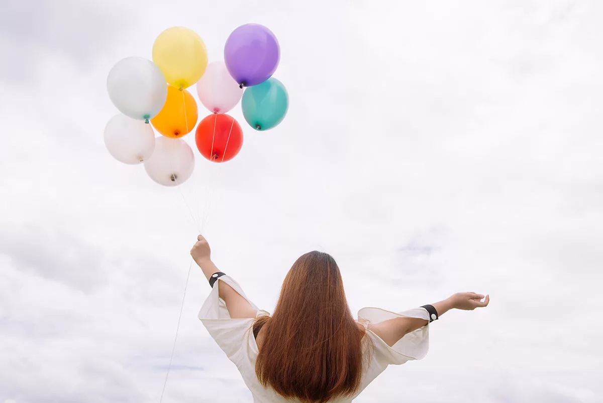 woman with balloons celebrating 2023 giveaway winners