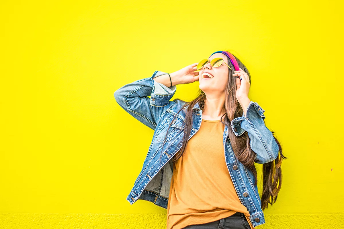 Person enjoying music against yellow wall, celebrating december 2023 winners