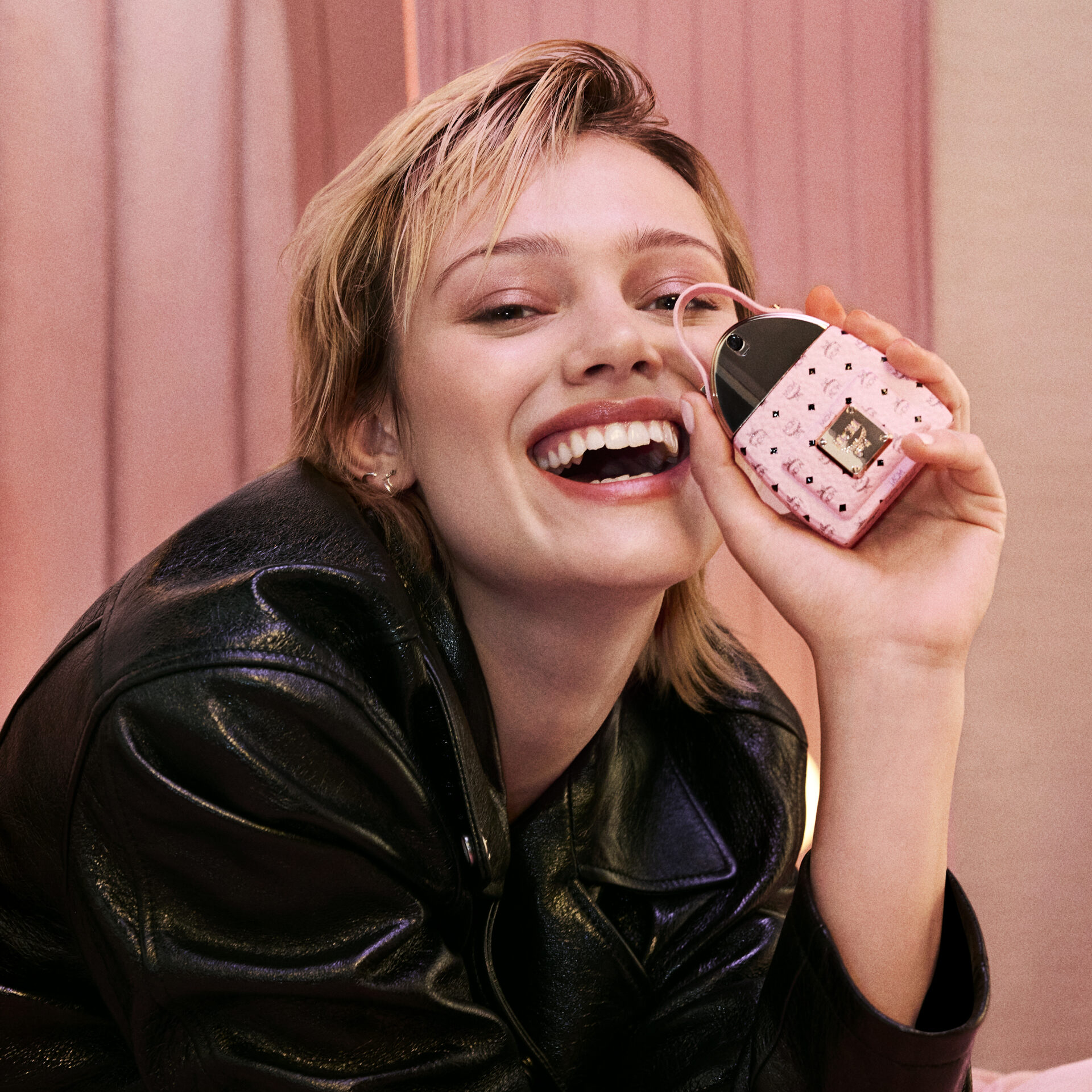 smiling woman holding MCM CRUSH Eau de Parfum fragrance