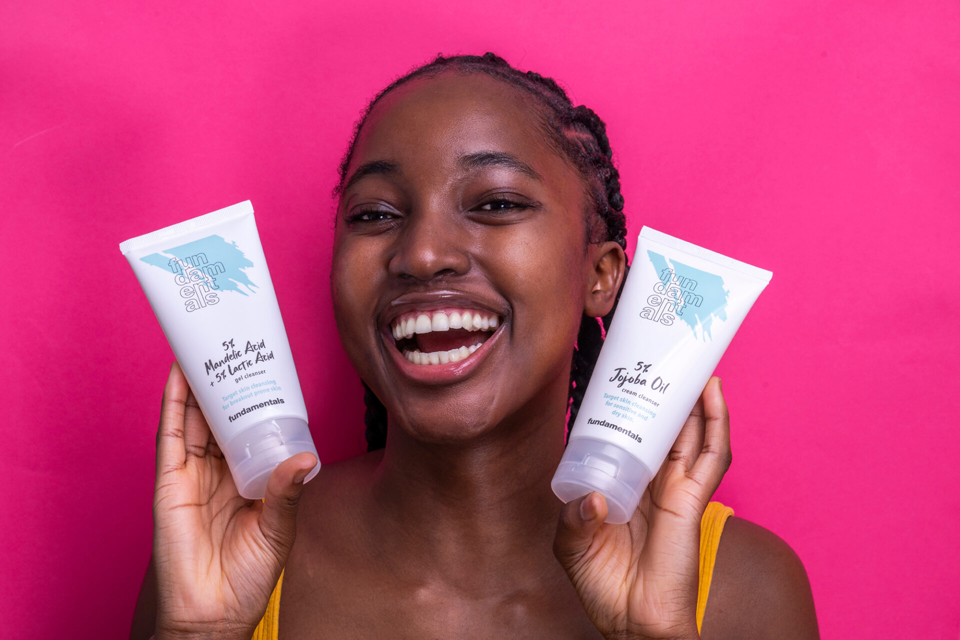 woman holding skincare products by fundamentals