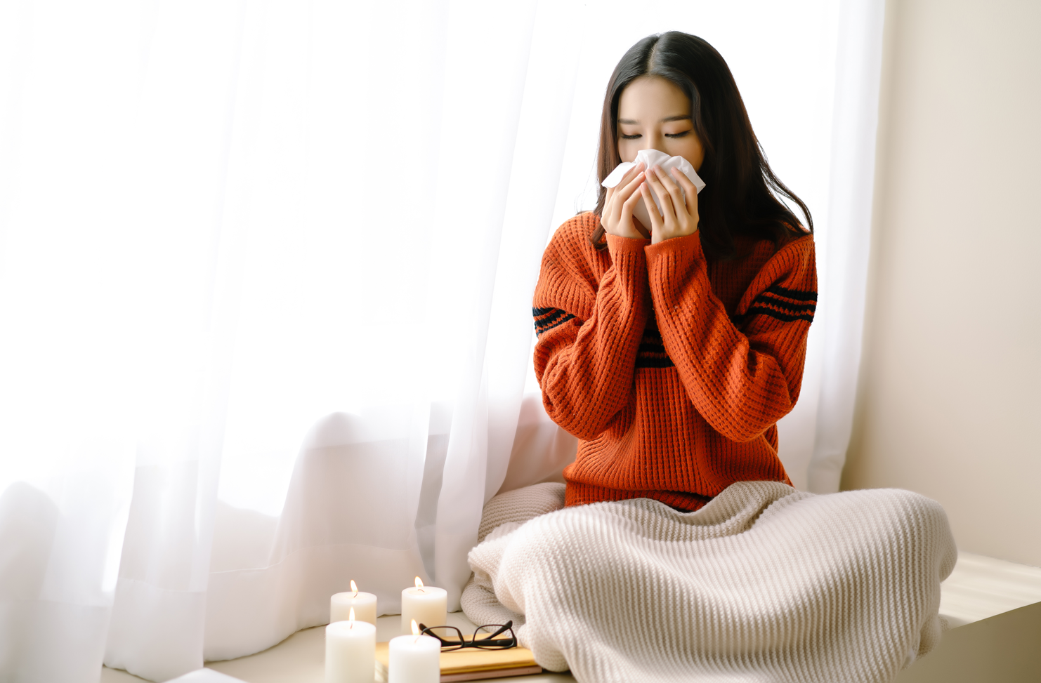 girl with allergies, blowing her nose