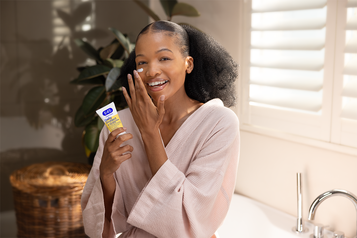 Transition Your Skincare from Winter to Spring and Summer With E45 2 Woman applying E45 skincare product indoors.