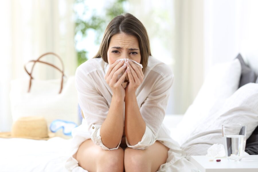 Woman sitting on bed with linctagon allergies