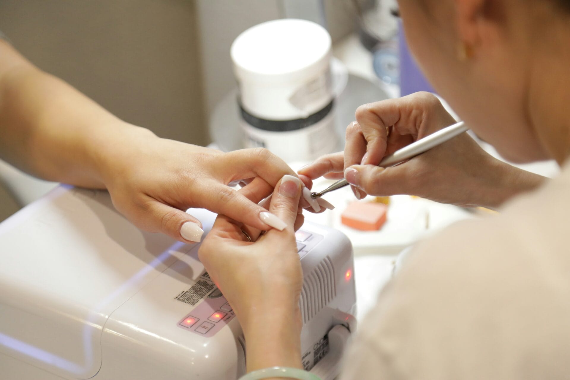 Nail technician applying gel nail polish