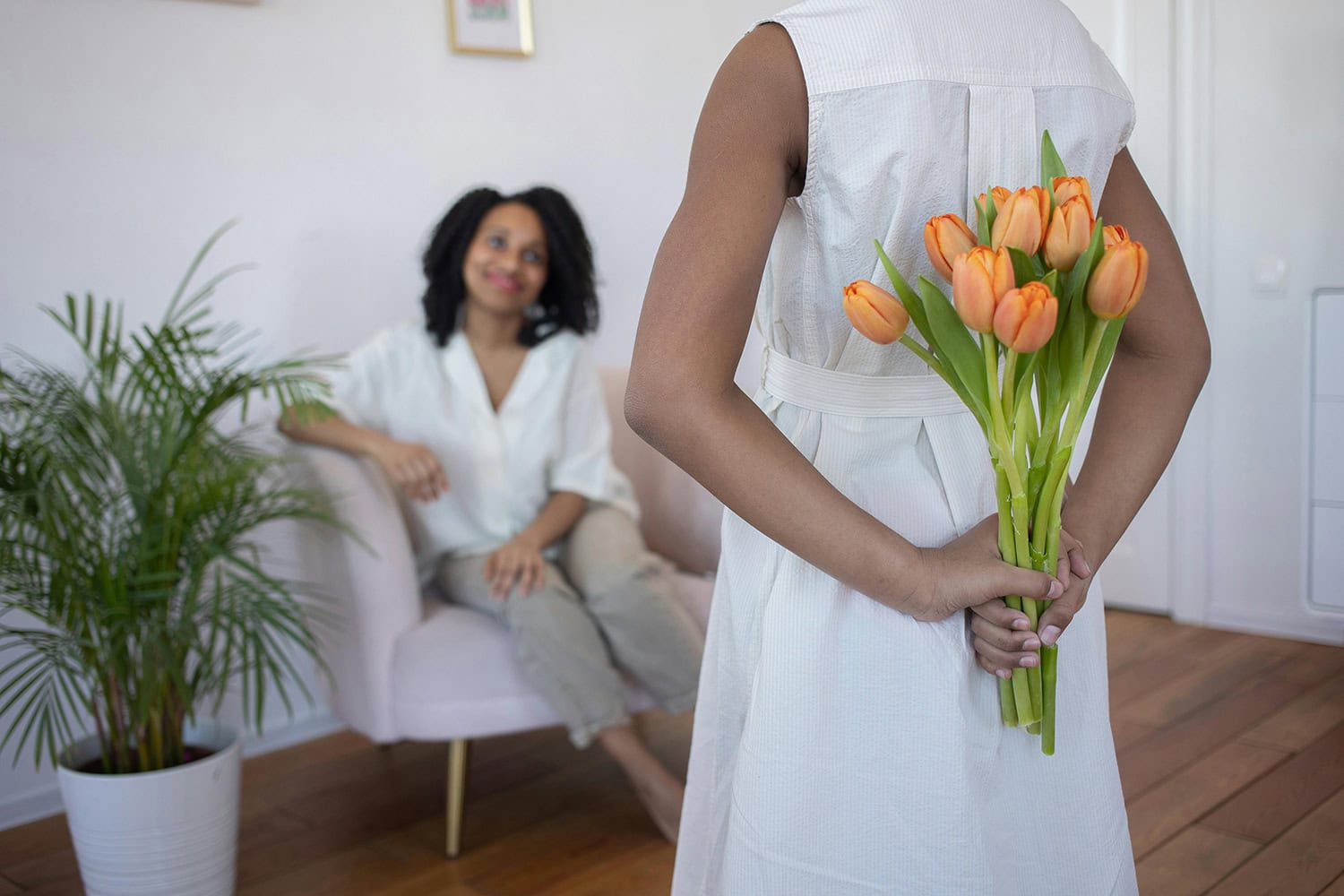 girl surprising her mom with mother's day flowers