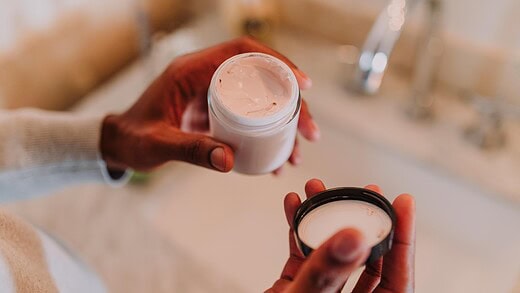 woman holding face cream