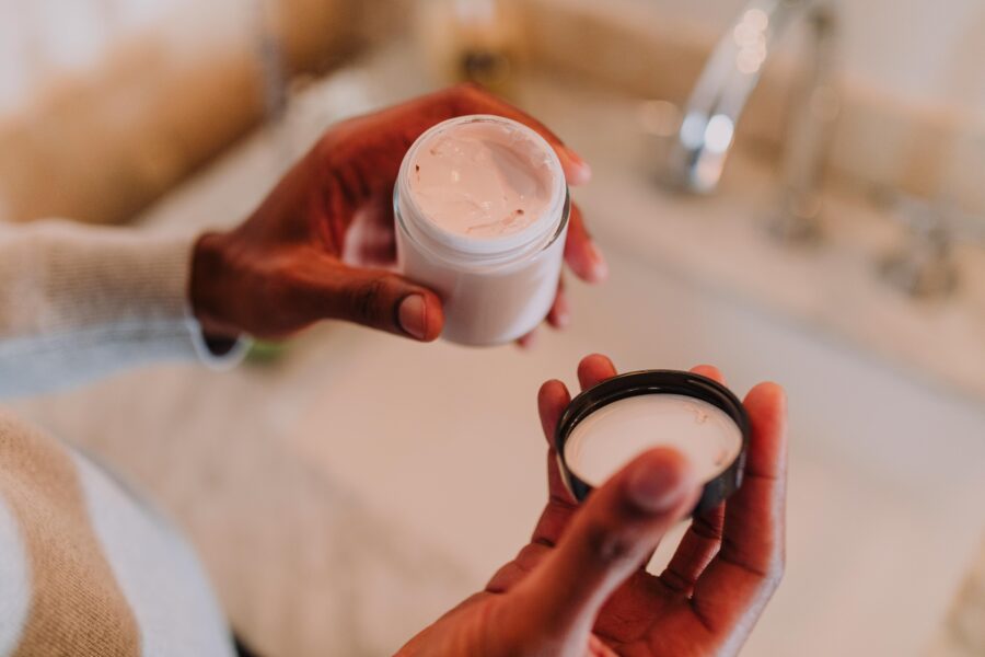 woman holding face cream